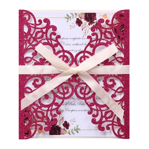 Detail of rose red glitter laser cut invitation with white card and cream satin bow