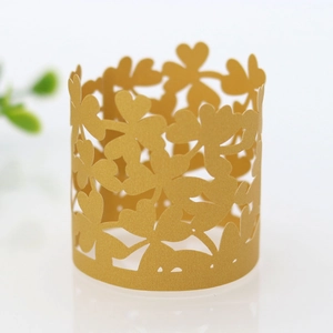 Macro shot of laser-cut gold pearlescent paper napkin ring with clover and heart patterns
