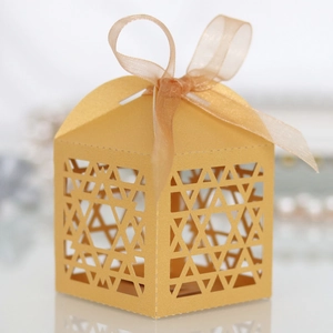 Detail of laser-cut Hanukkah candy box with gold star pattern and silk ribbon bow