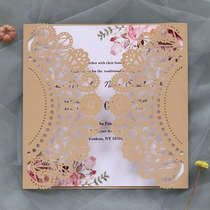 Detail of laser-cut lace wedding invitation with floral inner card and kraft paper shell