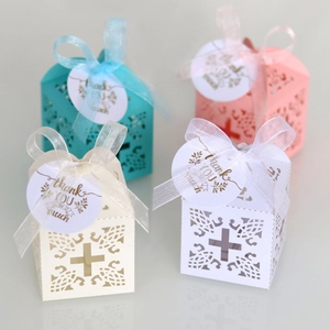Detail of laser-cut cross gift boxes with ribbons and Thank You tags in four pastel colors