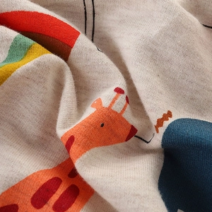 Macro view of soft cotton kids sweatshirt fabric with cute giraffe and rainbow print