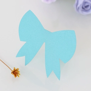 Macro detail of a light blue 3D paper bow place card with glitter texture for weddings