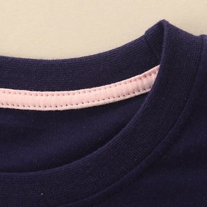 Detail van de marineblauwe katoenen t-shirt kraag met roze bies en geribbelde hals