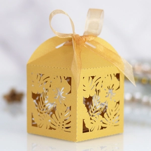 Detailed laser cut hibiscus flower and tropical leaf pattern on gold candy box
