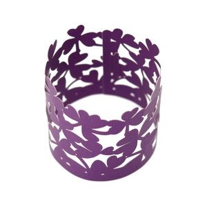 Macro view of purple laser cut floral napkin ring made of pearlescent paper for parties