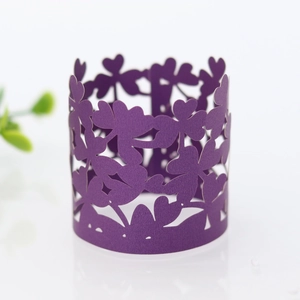 Macro shot of purple pearlescent paper cupcake wrapper with intricate clover cutout design