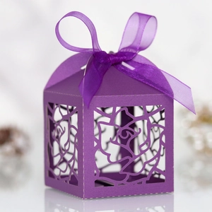 Detail of laser-cut rose patterns and purple satin bow on the wedding favor box