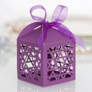 Detail of purple laser-cut candy box with star pattern and elegant silk ribbon