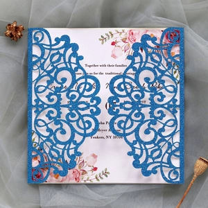 Detail of laser-cut wedding invitation with blue glitter finish and floral insert