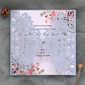 Détail d'un faire-part de mariage découpé au laser avec étui bleu et carte florale rose