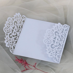 Détail de la pochette d'invitation blanche découpée au laser avec motifs floraux