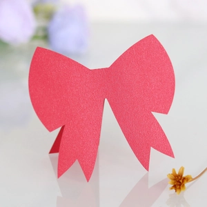 Macro detail of red 3D bow place card with pearlescent texture for wedding tables
