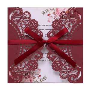 Elegant laser-cut burgundy lace wedding invitation set with silk ribbon and floral insert
