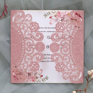 Macro shot of glitter laser-cut lace wedding card with floral insert on mesh
