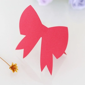 Detail view of 3D red paper bow place card for weddings with a smooth matte finish
