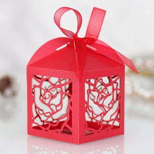 Detail of red laser-cut rose hollow candy box with an elegant silk ribbon bow