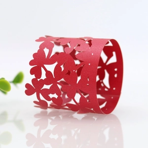 Close-up of red hollow laser-cut clover pattern paper napkin ring for party table decor