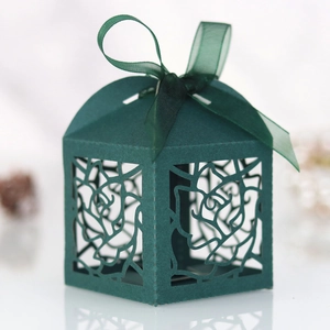 Detail of laser-cut rose patterns on elegant dark green favor box with a silk ribbon bow