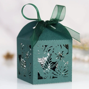 Detailed laser-cut dark green wedding candy box with tropical leaf patterns and silk bow