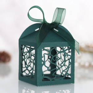 Close-up of laser-cut rose hollow paper gift box in dark green with organza ribbon