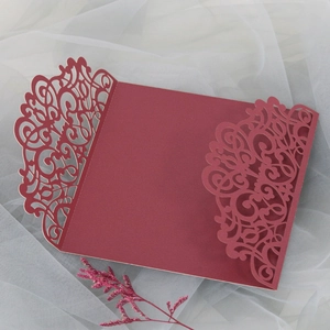 Détail de l'invitation de mariage bordeaux découpée au laser avec motifs floraux sur tulle