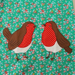 Floral girls' dress with cute bird embroidery and pink flower patterns on green fabric