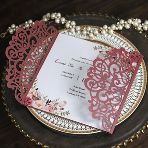 Détail d'invitation de mariage bordeaux découpée au laser avec insert floral élégant