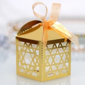 Detailed view of golden cutout candy box with hexagonal star pattern and ribbon bow