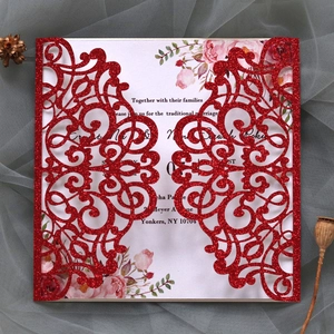Detail of red glitter laser-cut wedding invitation with elegant floral inner page card