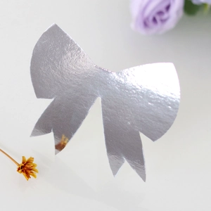 Close-up of laser-cut silver bow place cards with mirror metallic finish for wedding tables
