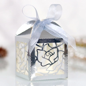 Macro shot of silver laser-cut rose gift box with blue silk ribbon detail