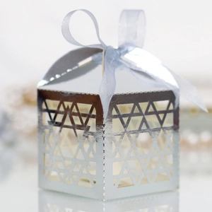 Close-up of silver cutout gift box with geometric pattern and light blue ribbon bow