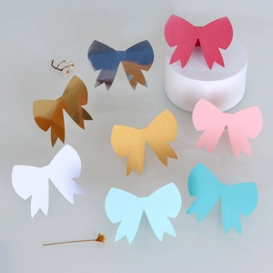 Macro view showing eight colorful 3D bowknot place cards with matte and metallic finishes