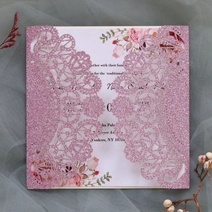 Detail of pink glitter laser-cut wedding invitation with elegant floral inner card