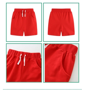 Detail view of red knitted boys shorts with elastic waistband and white drawstring