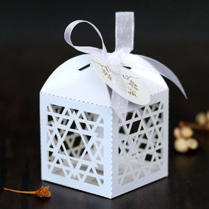 Detail of white laser-cut Hanukkah candy box with hollow star design and ribbon bow