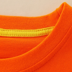 Detail of bright orange boys' crew neck T-shirt with reinforced yellow neck tape