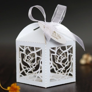 Detailed laser-cut rose pattern on white cardstock gift box with silk ribbon and tag