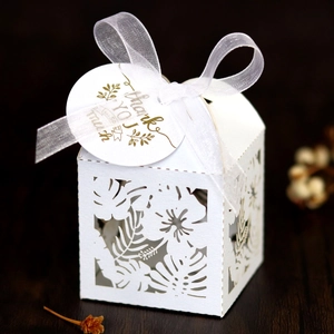 Detail of laser-cut hibiscus leaf gift box with white organza ribbon and thank you tag