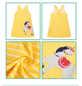 Detail of yellow striped cotton dress showing unicorn embroidery and cross-back straps