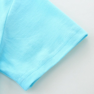 Détail de la manche d'un t-shirt bleu clair pour garçon avec couture à double aiguille