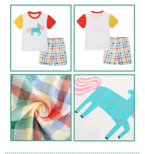 Detail of girls cotton knit unicorn tee and plaid shorts with multicolor patchwork sleeves