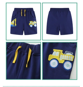 Detail view of boys navy blue cotton shorts featuring yellow drawstring and truck embroidery