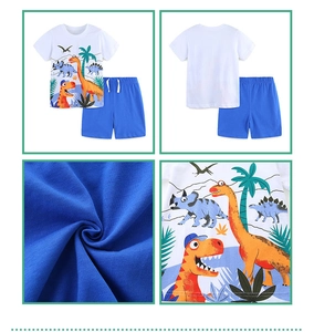 Detail of boys' knit cotton set with cartoon dinosaur prints on white tee and blue shorts
