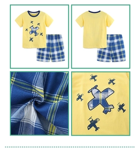 Detail of boys' yellow cotton t-shirt and blue plaid shorts with plane applique