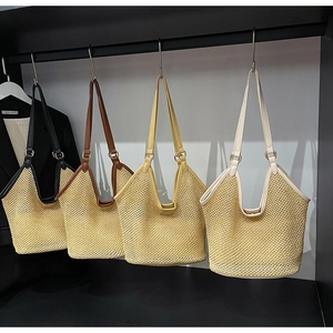Détail de quatre sacs cabas en paille tissée avec bordure en cuir noir, marron, jaune et beige