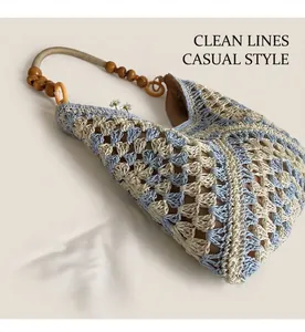 Detail of blue and beige woven tote bag with hollow patterns and wood bead strap accents