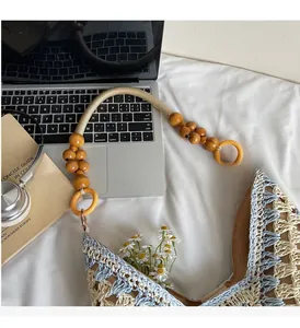 Detail of wooden bead handle on a blue and beige woven tote bag for summer vacation