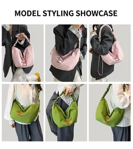 Detail showing pink and green canvas tote bags with pleated straps and letter embroidery